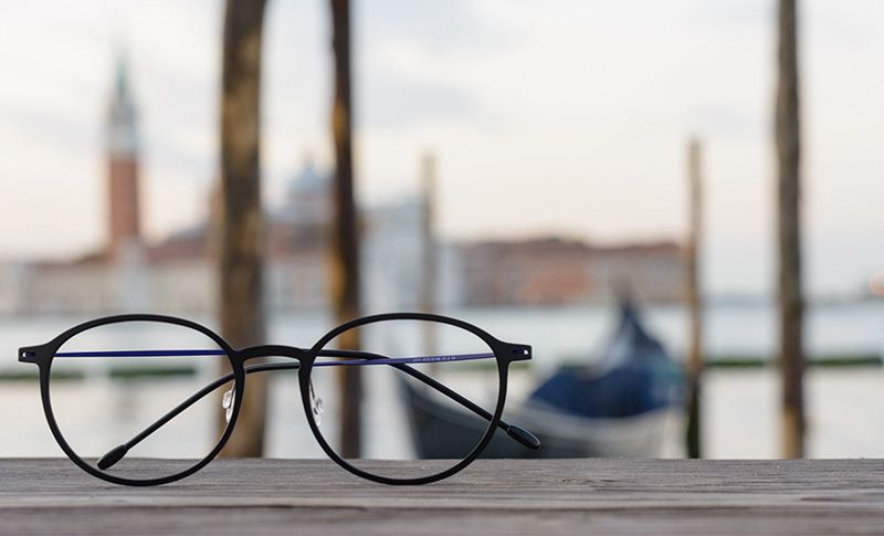 glasses on a table with the ocean in the background
